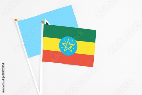 Ethiopia and Saint Lucia stick flags on white background. High quality fabric, miniature national flag. Peaceful global concept.White floor for copy space. photo