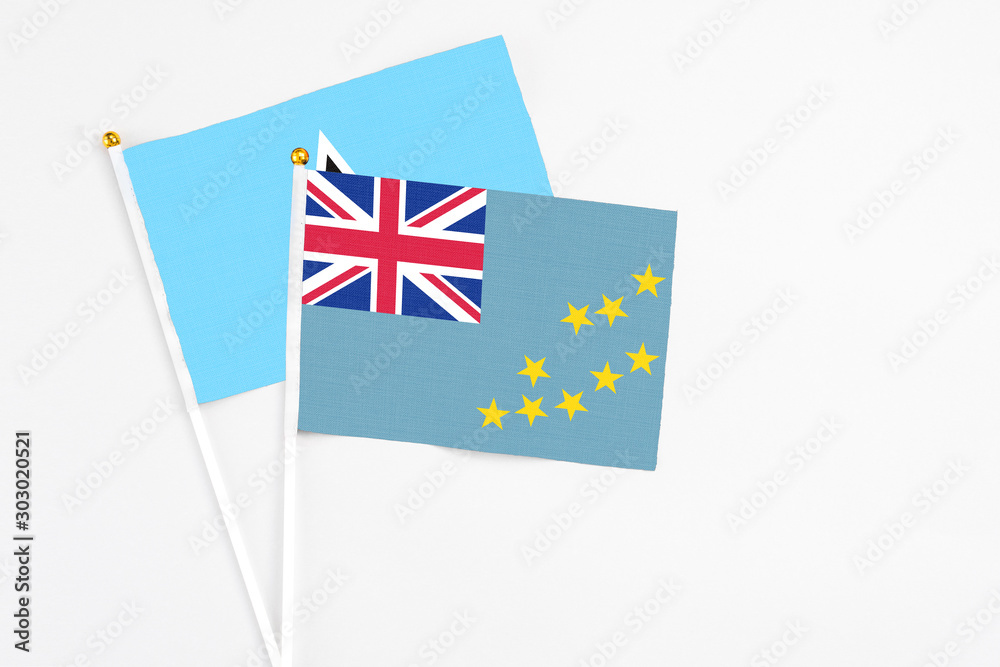Fototapeta premium Tuvalu and Saint Lucia stick flags on white background. High quality fabric, miniature national flag. Peaceful global concept.White floor for copy space.