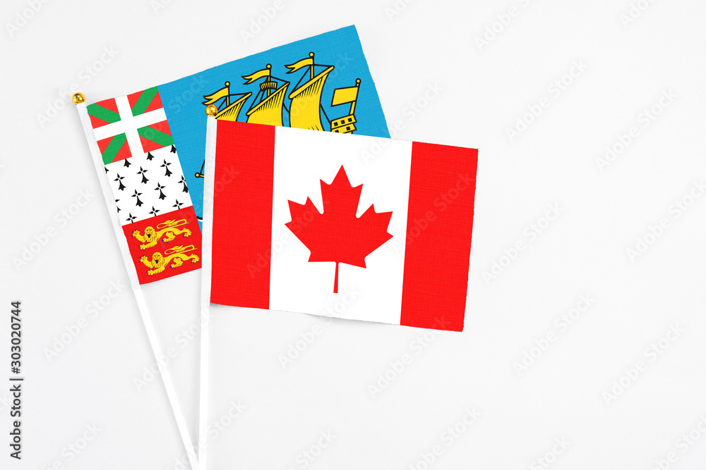 Canada and Saint Pierre And Miquelon stick flags on white background. High quality fabric, miniature national flag. Peaceful global concept.White floor for copy space. Canada and Saint Pierre And Miquelon stick flags on white background. High quality fabric, miniature national flag. Peaceful global concept.White floor for copy space.