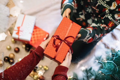 Female hands receiving red Christmas present from child photo