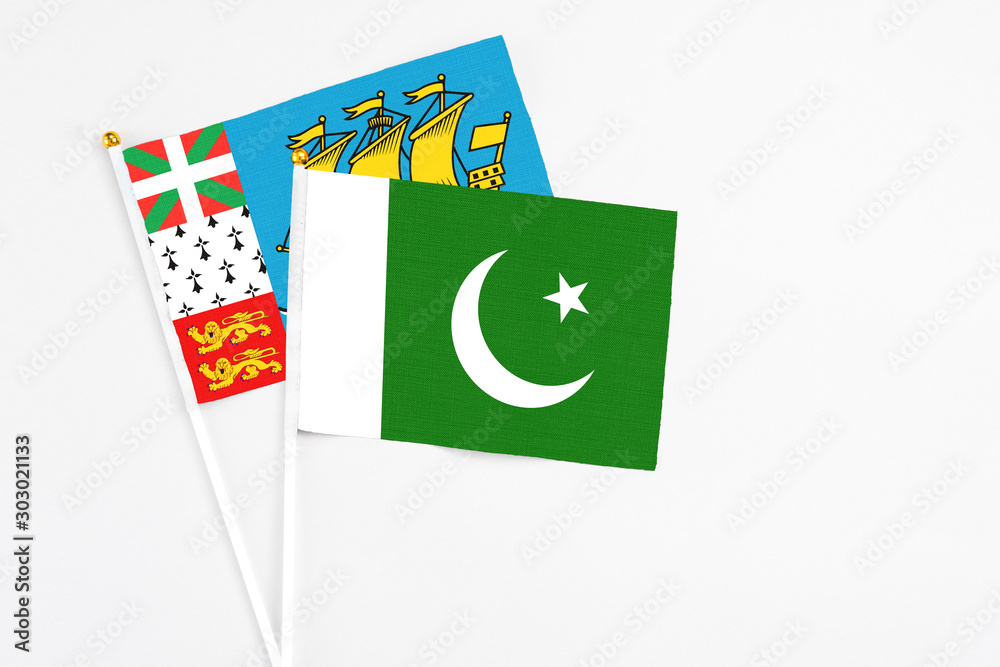 Pakistan and Saint Pierre And Miquelon stick flags on white background. High quality fabric, miniature national flag. Peaceful global concept.White floor for copy space. Pakistan and Saint Pierre And Miquelon stick flags on white background. High quality fabric, miniature national flag. Peaceful global concept.White floor for copy space.