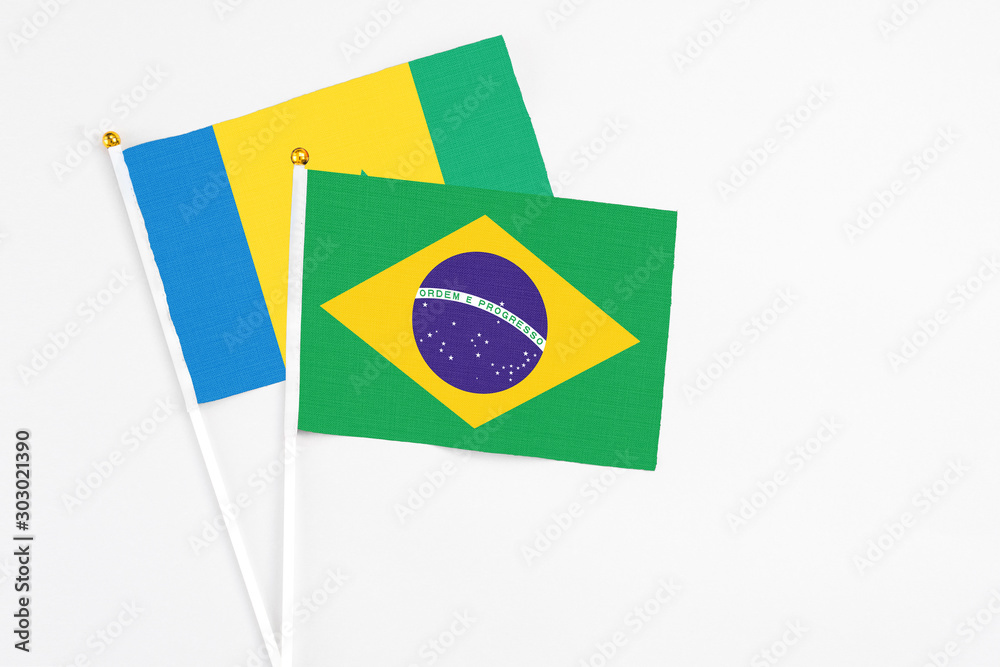 Brazil and Saint Vincent And The Grenadines stick flags on white background. High quality fabric, miniature national flag. Peaceful global concept.White floor for copy space.