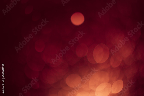 Red gold Festive Christmas Beautiful abstract Background with bokeh lights. Holiday Texture with copy space. Can be used as Wallpaper, filling for a website, defocused