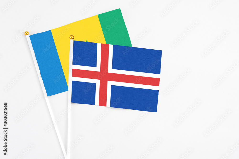 Iceland and Saint Vincent And The Grenadines stick flags on white background. High quality fabric, miniature national flag. Peaceful global concept.White floor for copy space.