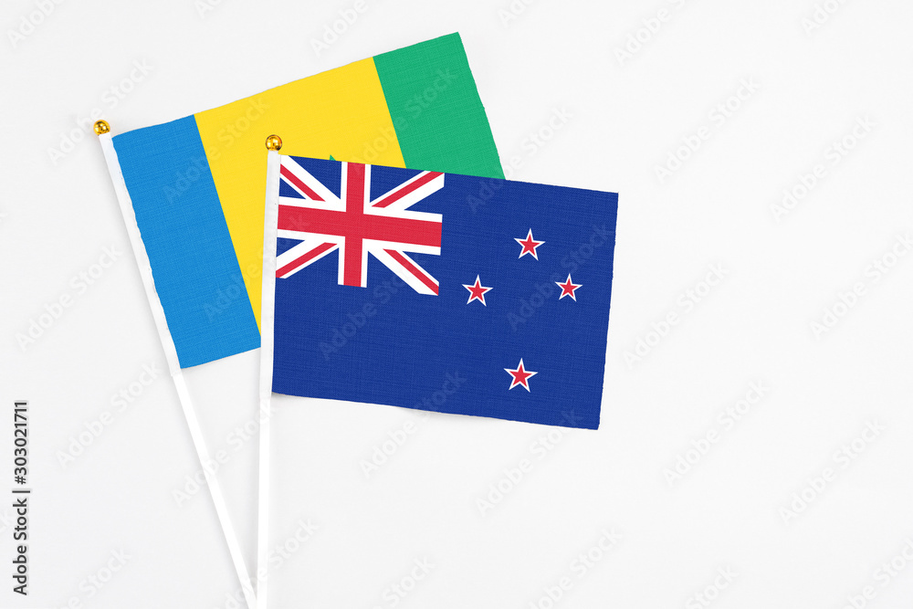 Fototapeta premium New Zealand and Saint Vincent And The Grenadines stick flags on white background. High quality fabric, miniature national flag. Peaceful global concept.White floor for copy space.