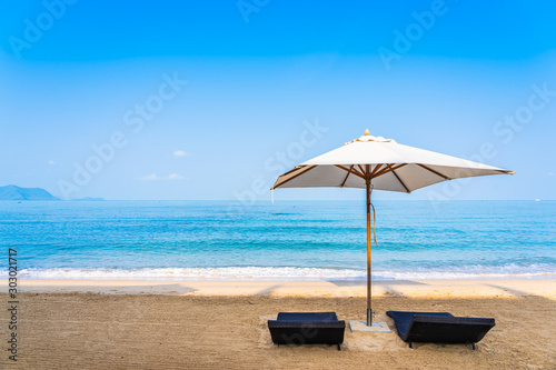 Chair umbrella and lounge on the beautiful beach sea ocean on sky © siraphol