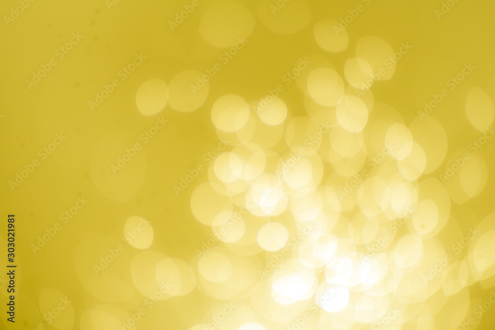 Yellow Gold Festive Christmas Beautiful abstract Background with bokeh lights. Holiday Texture with copy space. Can be used as Wallpaper, filling for a website, defocused