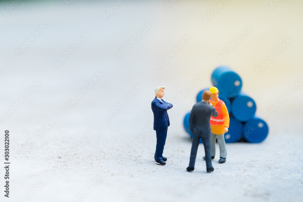 Miniature People : Two business man and engineer standing in front of drums pile with copy space, industrial concept, use as wallpaper Miniature People : Two business man and engineer standing in front of drums pile with copy space, industrial concept, use as wallpaper
