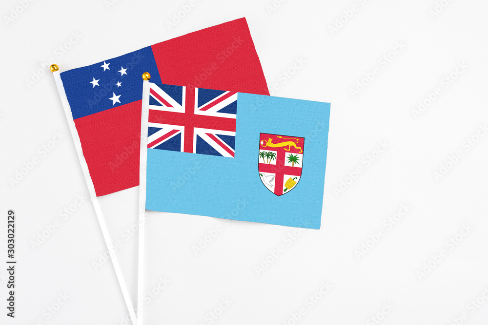 Fototapeta premium Fiji and Samoa stick flags on white background. High quality fabric, miniature national flag. Peaceful global concept.White floor for copy space.