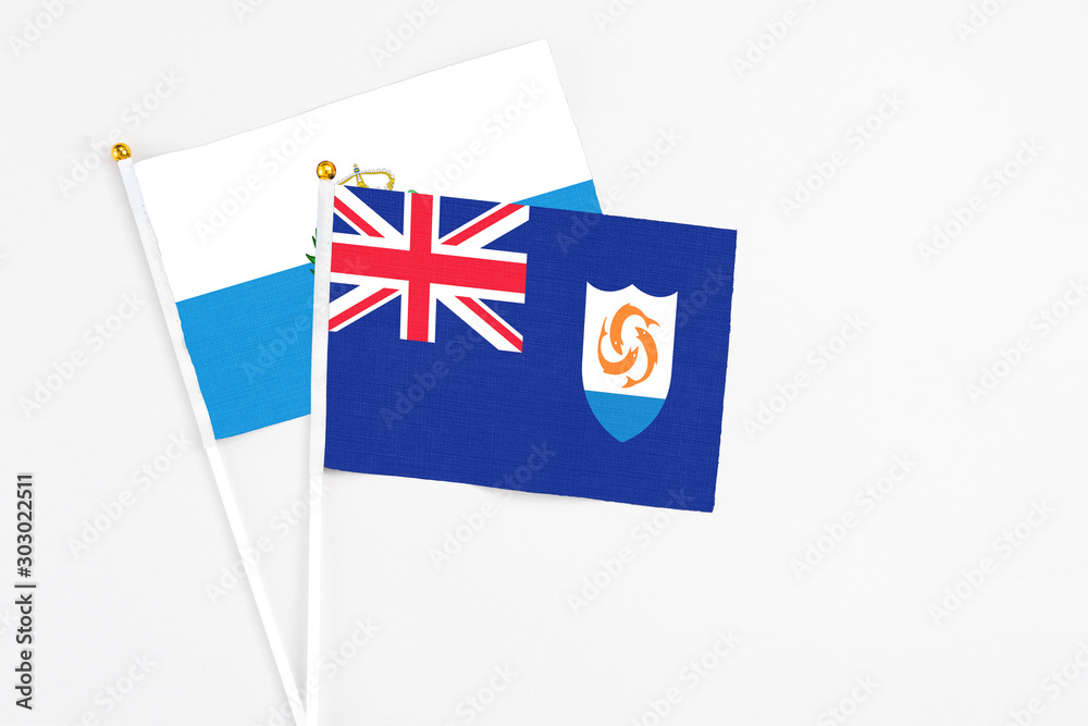 Fototapeta premium Anguilla and San Marino stick flags on white background. High quality fabric, miniature national flag. Peaceful global concept.White floor for copy space.