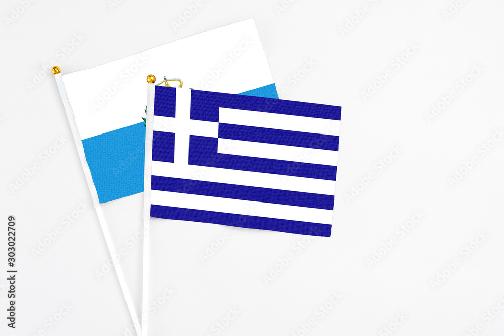 Obraz premium Greece and San Marino stick flags on white background. High quality fabric, miniature national flag. Peaceful global concept.White floor for copy space.