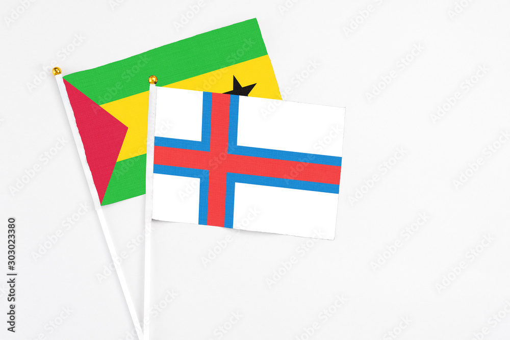 Faroe Islands and Sao Tome And Principe stick flags on white background. High quality fabric, miniature national flag. Peaceful global concept.White floor for copy space.