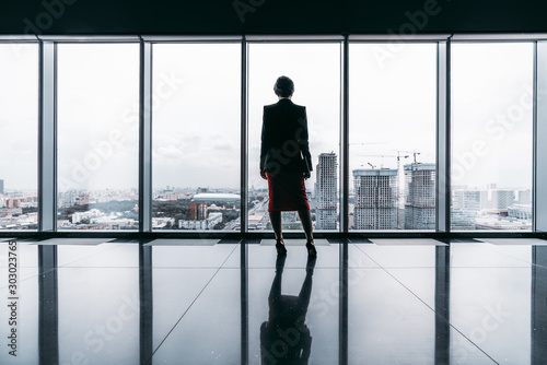 Photography Rearview of a female entrepreneur on the top of a modern business office skyscra