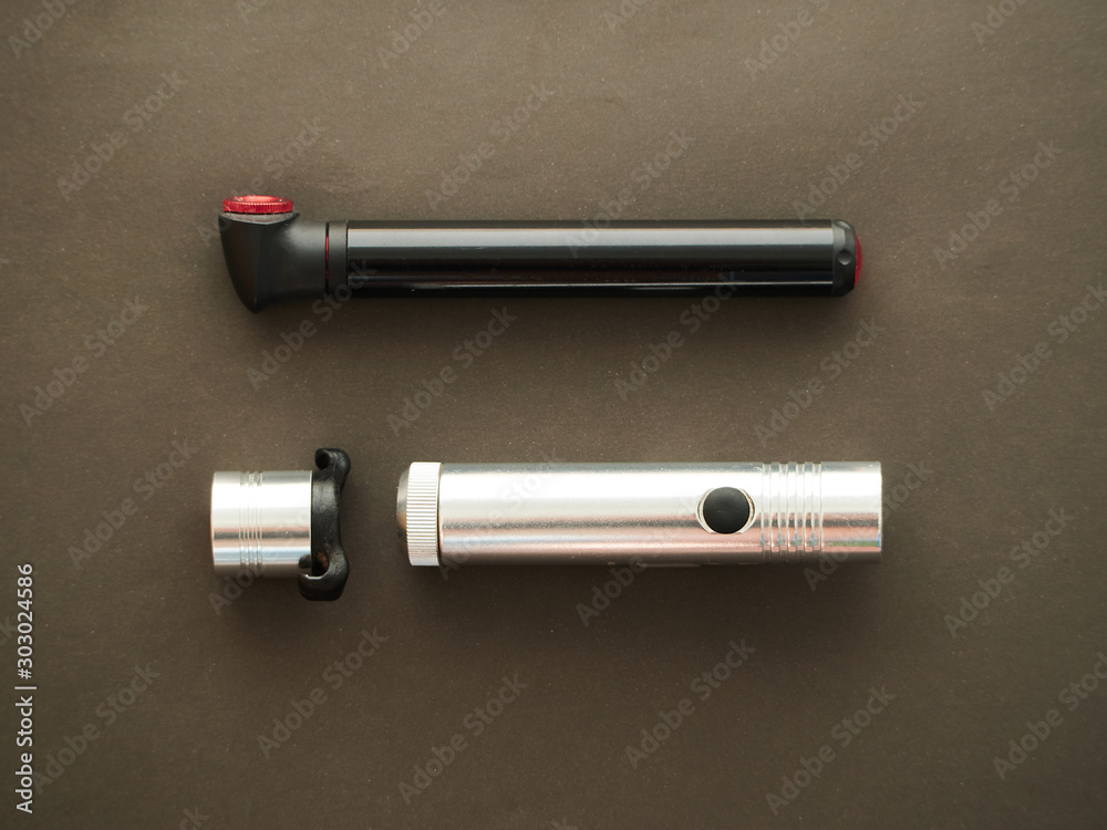 Naklejka premium Bike lights. Red white bike lights on dark background with a portable pump.