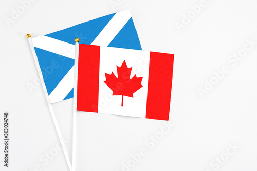Canada and Scotland stick flags on white background. High quality fabric, miniature national flag. Peaceful global concept.White floor for copy space.