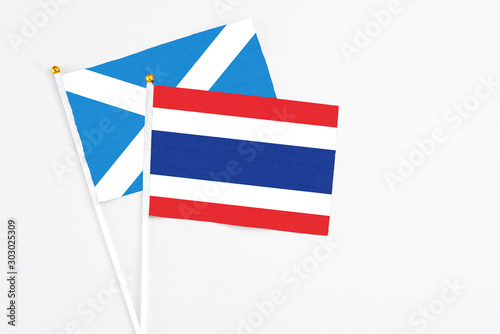 Thailand and Scotland stick flags on white background. High quality fabric, miniature national flag. Peaceful global concept.White floor for copy space.