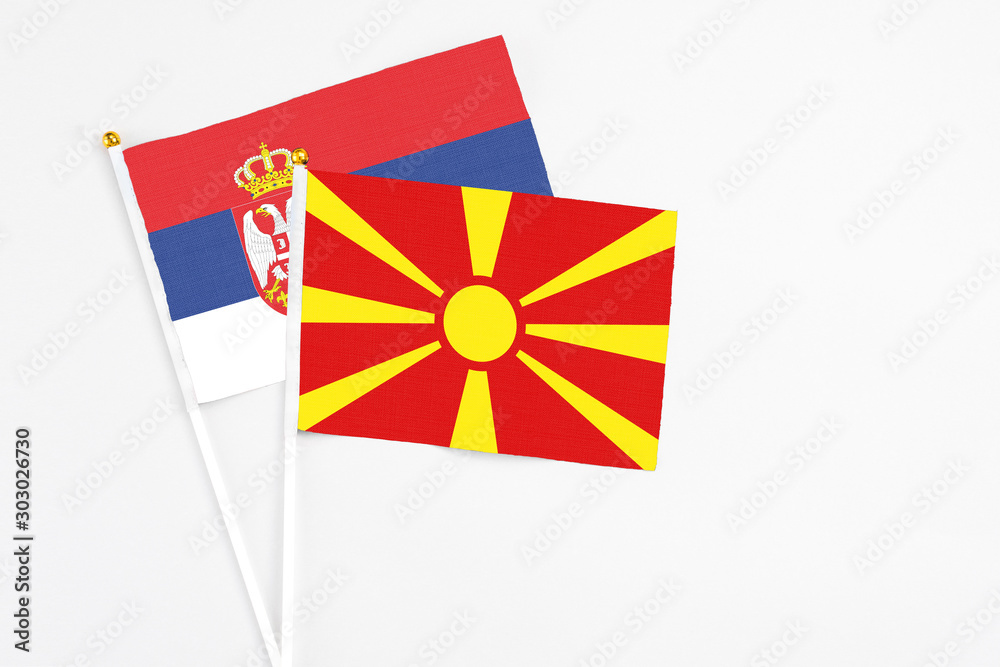 Macedonia and Serbia stick flags on white background. High quality fabric, miniature national flag. Peaceful global concept.White floor for copy space.