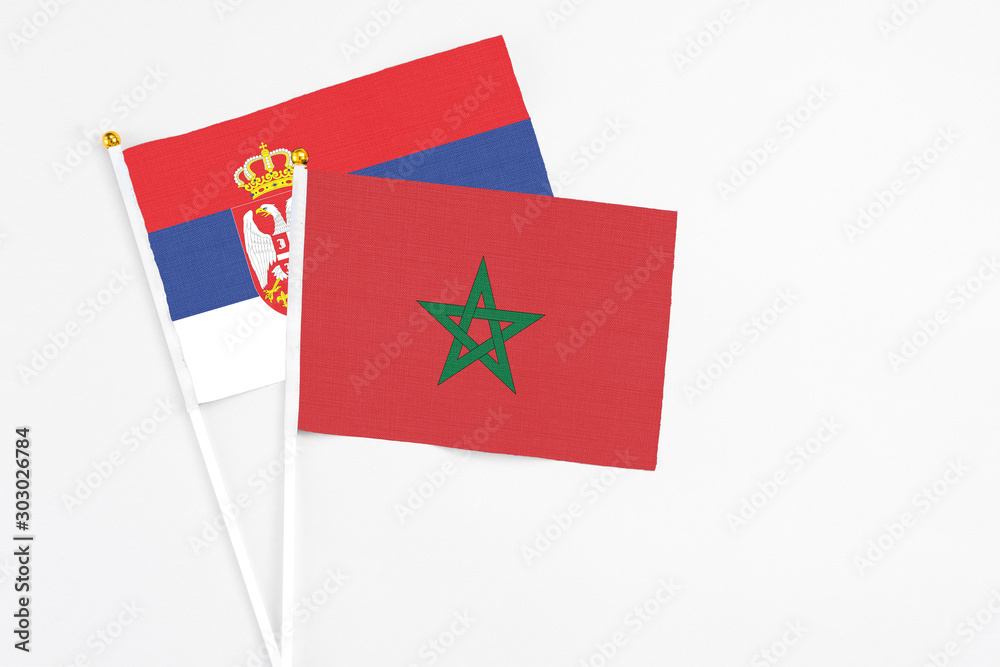 Morocco and Serbia stick flags on white background. High quality fabric, miniature national flag. Peaceful global concept.White floor for copy space. Morocco and Serbia stick flags on white background. High quality fabric, miniature national flag. Peaceful global concept.White floor for copy space.
