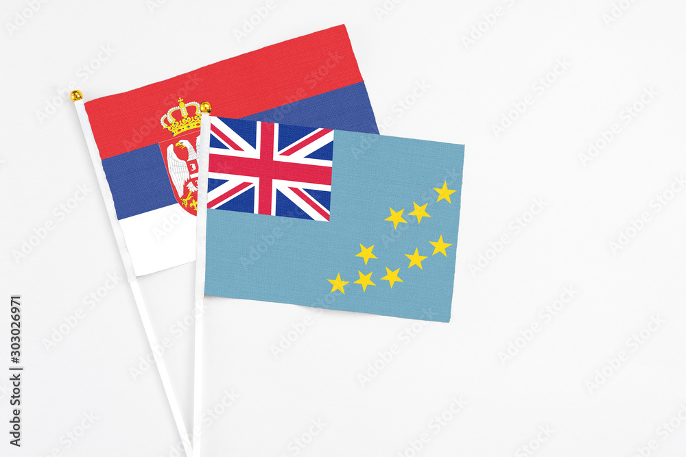 Tuvalu and Serbia stick flags on white background. High quality fabric, miniature national flag. Peaceful global concept.White floor for copy space.