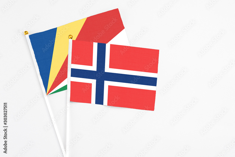 Norway and Seychelles stick flags on white background. High quality fabric, miniature national flag. Peaceful global concept.White floor for copy space.v