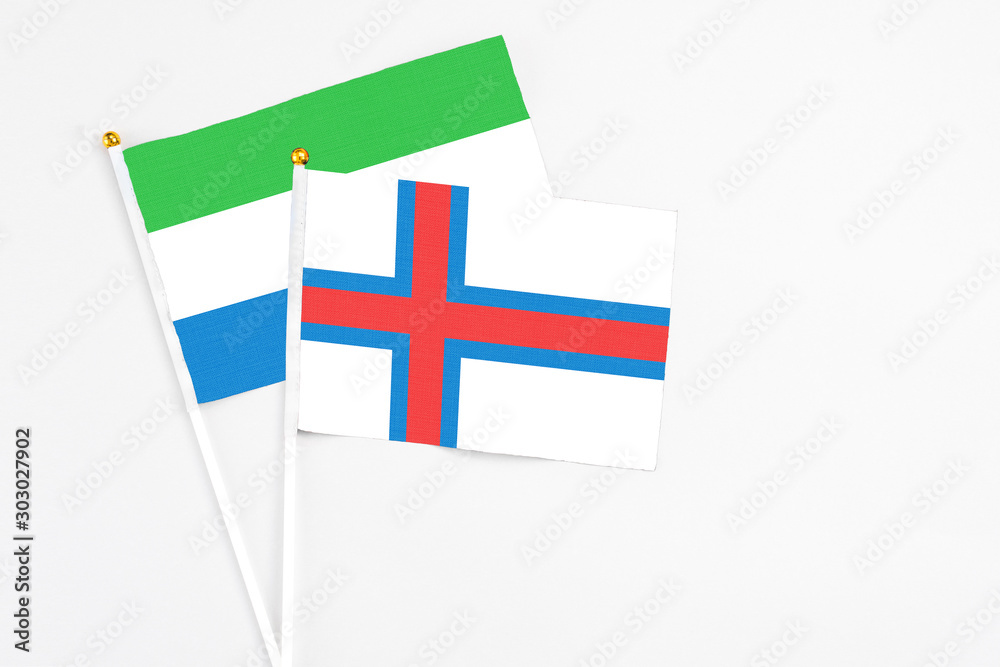 Faroe Islands and Sierra Leone stick flags on white background. High quality fabric, miniature national flag. Peaceful global concept.White floor for copy space.