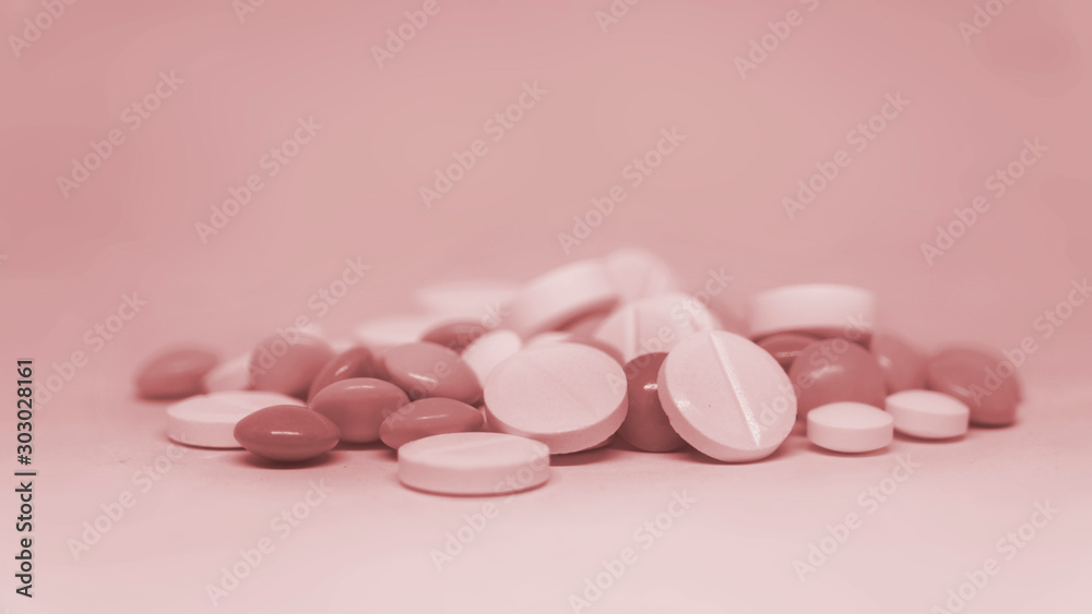 Various multicolor pills lying on rose background Various multicolor pills lying on rose background