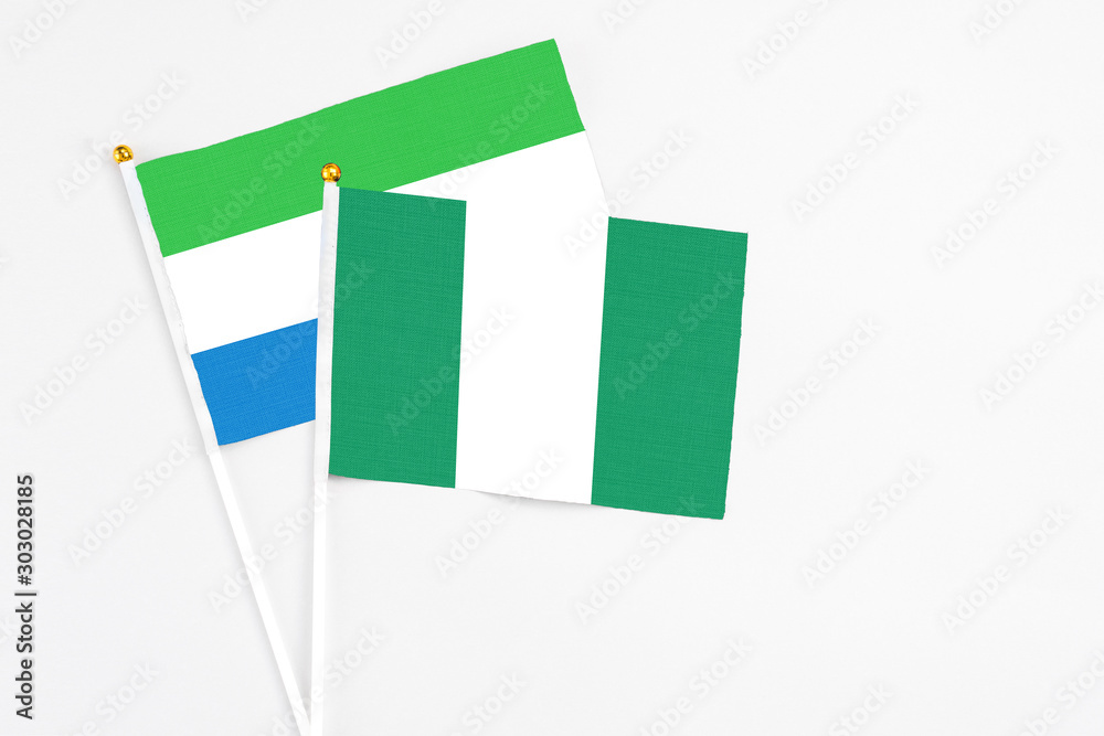 Nigeria and Sierra Leone stick flags on white background. High quality fabric, miniature national flag. Peaceful global concept.White floor for copy space. Nigeria and Sierra Leone stick flags on white background. High quality fabric, miniature national flag. Peaceful global concept.White floor for copy space.