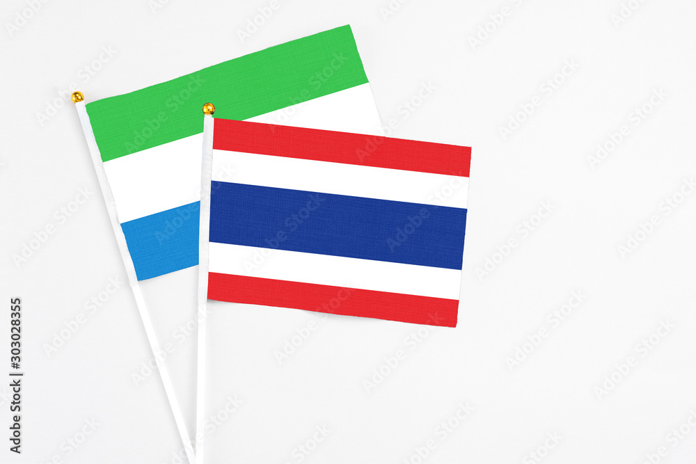 Thailand and Sierra Leone stick flags on white background. High quality fabric, miniature national flag. Peaceful global concept.White floor for copy space. Thailand and Sierra Leone stick flags on white background. High quality fabric, miniature national flag. Peaceful global concept.White floor for copy space.
