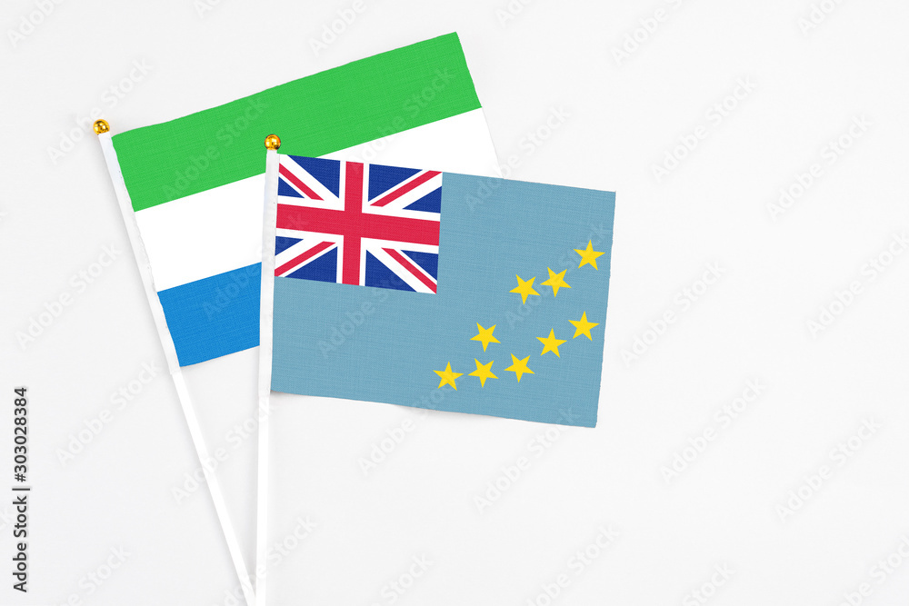 Fototapeta premium Tuvalu and Sierra Leone stick flags on white background. High quality fabric, miniature national flag. Peaceful global concept.White floor for copy space.