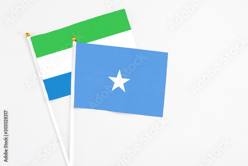 Free Download Somalia and Sierra Leone stick flags on white background. High quality fabric, miniature national flag. Peaceful global concept.White floor for copy space. - GFXLoad