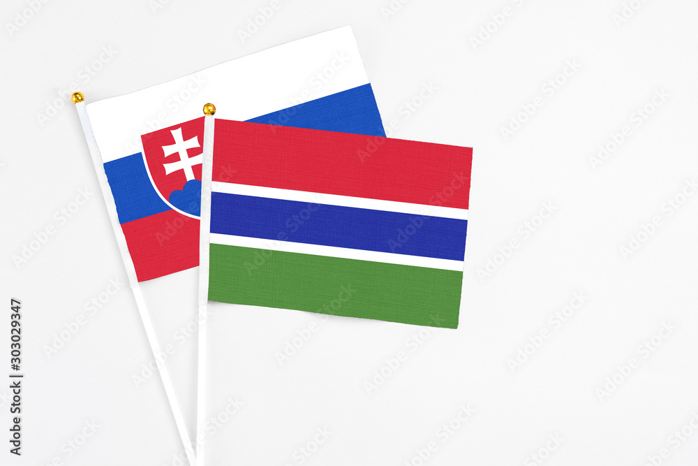 Gambia and Slovakia stick flags on white background. High quality fabric, miniature national flag. Peaceful global concept.White floor for copy space. Gambia and Slovakia stick flags on white background. High quality fabric, miniature national flag. Peaceful global concept.White floor for copy space.