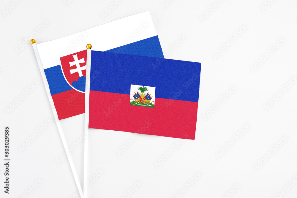 Haiti and Slovakia stick flags on white background. High quality fabric, miniature national flag. Peaceful global concept.White floor for copy space. Haiti and Slovakia stick flags on white background. High quality fabric, miniature national flag. Peaceful global concept.White floor for copy space.