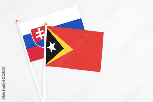 Free Download East Timor and Slovakia stick flags on white background. High quality fabric, miniature national flag. Peaceful global concept.White floor for copy space. - GFXLoad