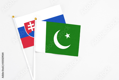 Pakistan and Slovakia stick flags on white background. High quality fabric, miniature national flag. Peaceful global concept.White floor for copy space.