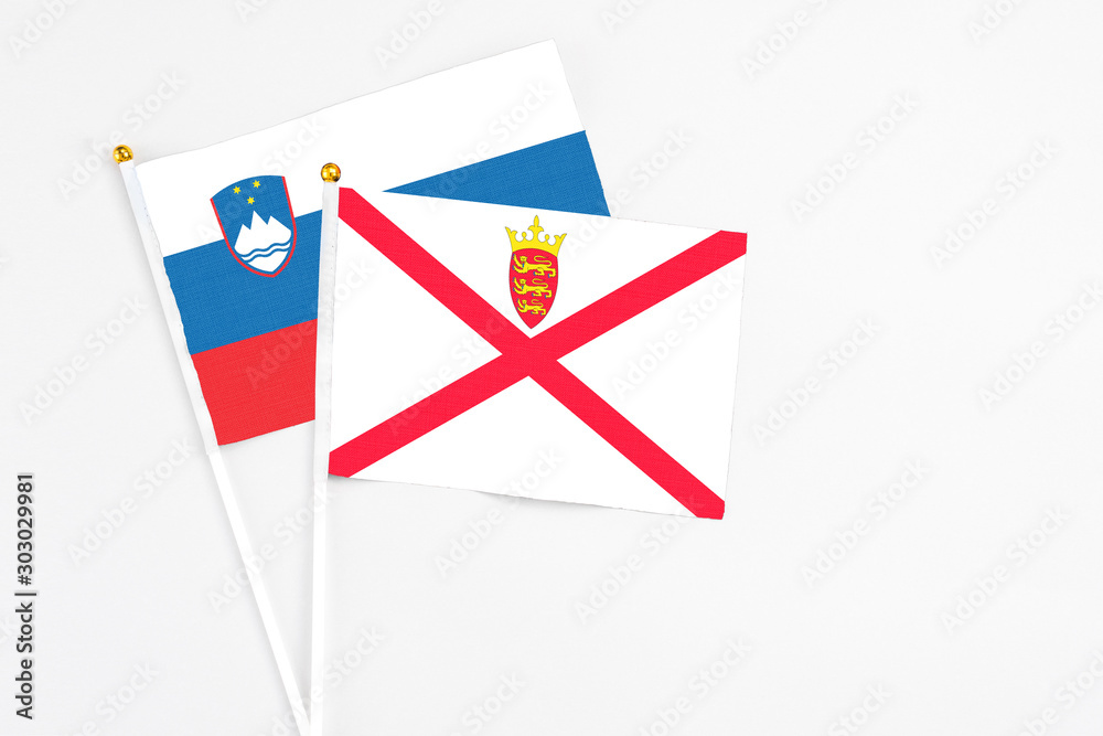 Jersey and Slovenia stick flags on white background. High quality fabric, miniature national flag. Peaceful global concept.White floor for copy space.