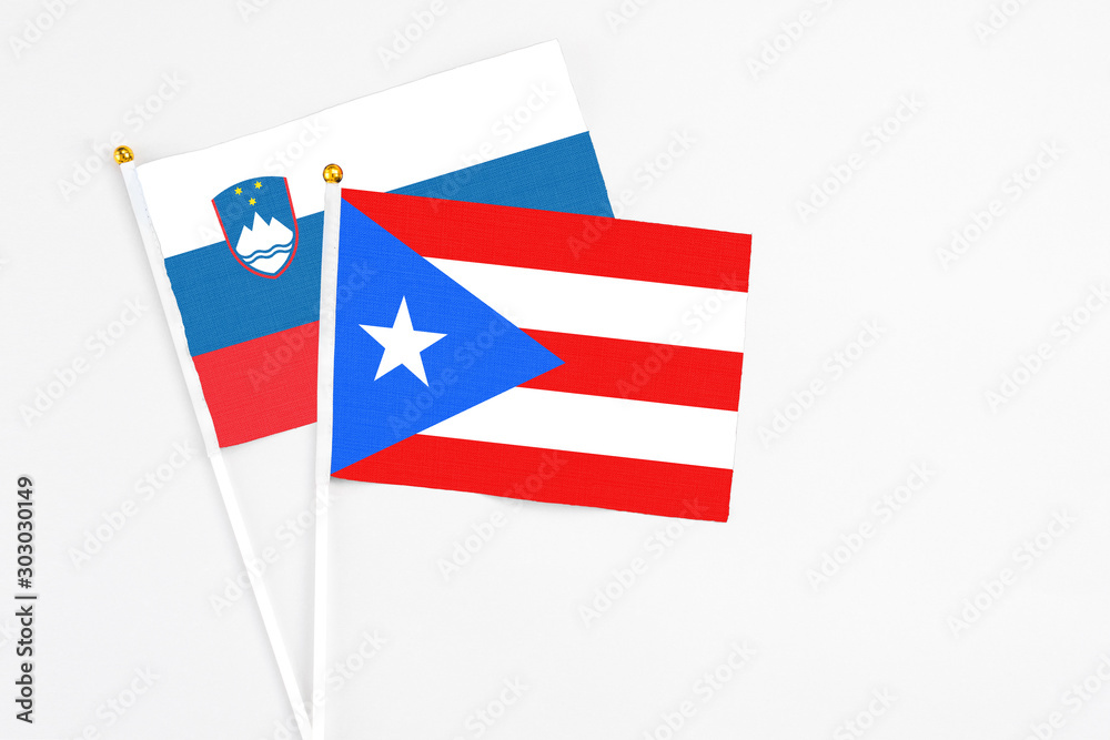 Puerto Rico and Slovenia stick flags on white background. High quality fabric, miniature national flag. Peaceful global concept.White floor for copy space. Puerto Rico and Slovenia stick flags on white background. High quality fabric, miniature national flag. Peaceful global concept.White floor for copy space.