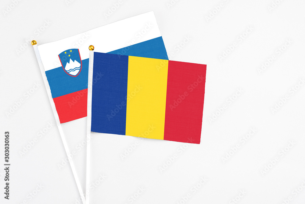 Romania and Slovenia stick flags on white background. High quality fabric, miniature national flag. Peaceful global concept.White floor for copy space. Romania and Slovenia stick flags on white background. High quality fabric, miniature national flag. Peaceful global concept.White floor for copy space.