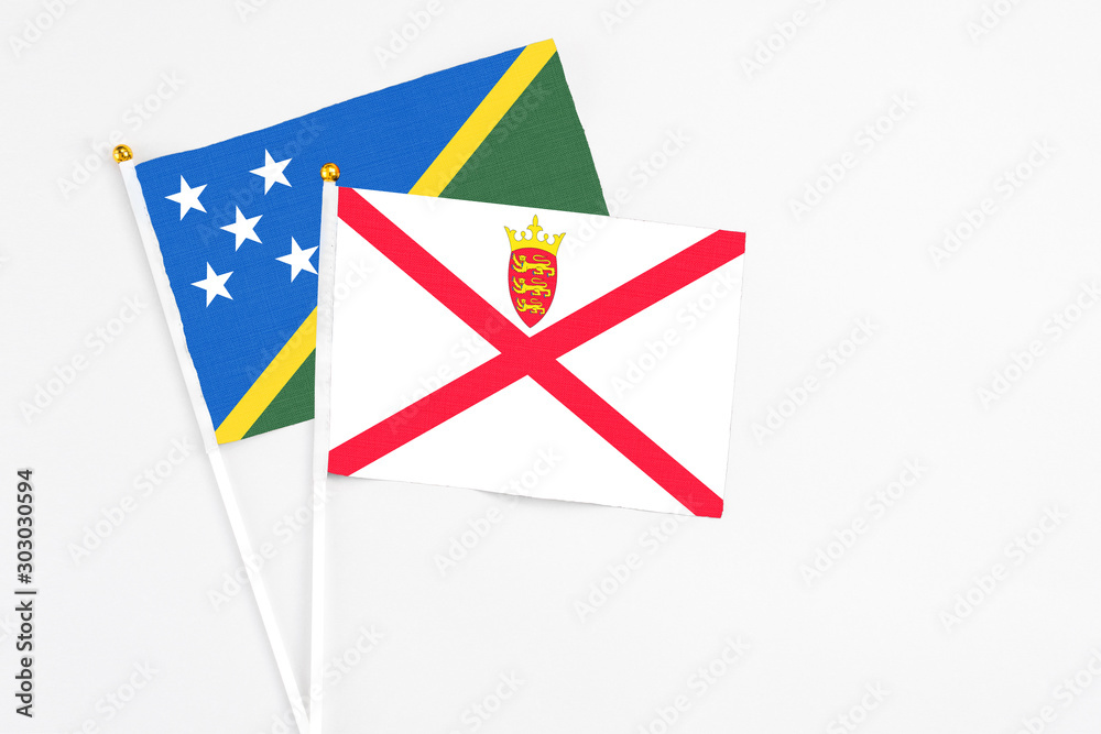Jersey and Solomon Islands stick flags on white background. High quality fabric, miniature national flag. Peaceful global concept.White floor for copy space. Jersey and Solomon Islands stick flags on white background. High quality fabric, miniature national flag. Peaceful global concept.White floor for copy space.
