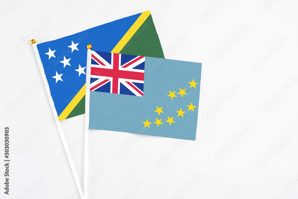 Tuvalu and Solomon Islands stick flags on white background. High quality fabric, miniature national flag. Peaceful global concept.White floor for copy space. Tuvalu and Solomon Islands stick flags on white background. High quality fabric, miniature national flag. Peaceful global concept.White floor for copy space.
