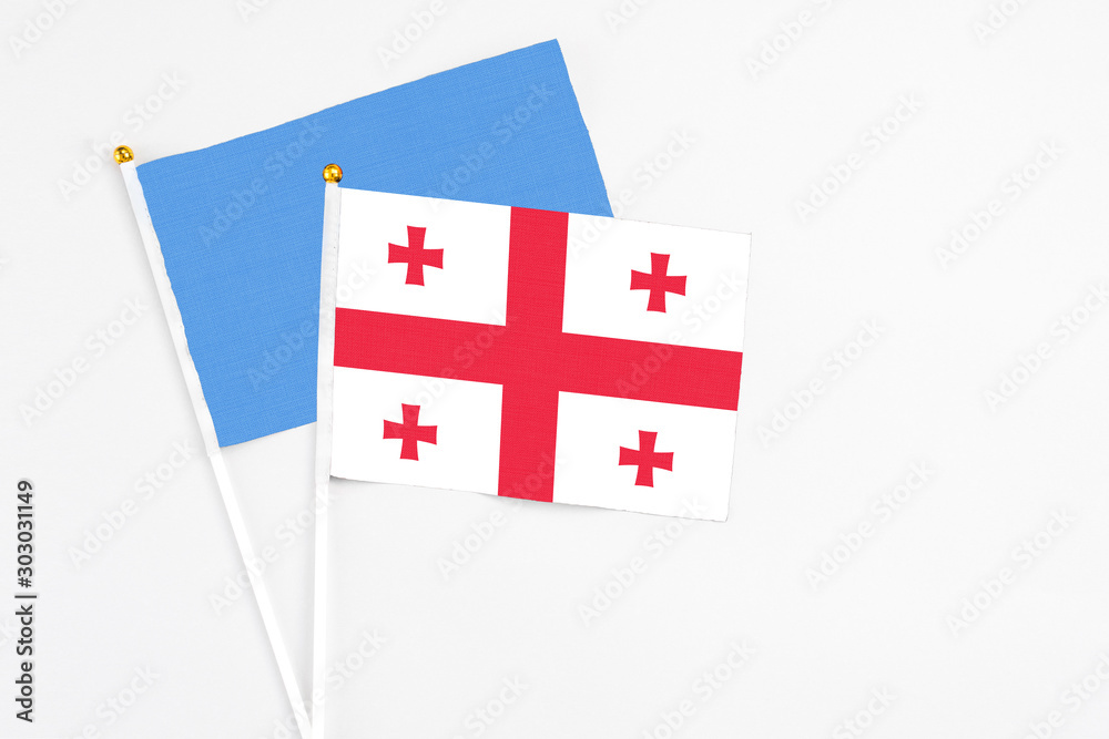 Georgia and Somalia stick flags on white background. High quality fabric, miniature national flag. Peaceful global concept.White floor for copy space.