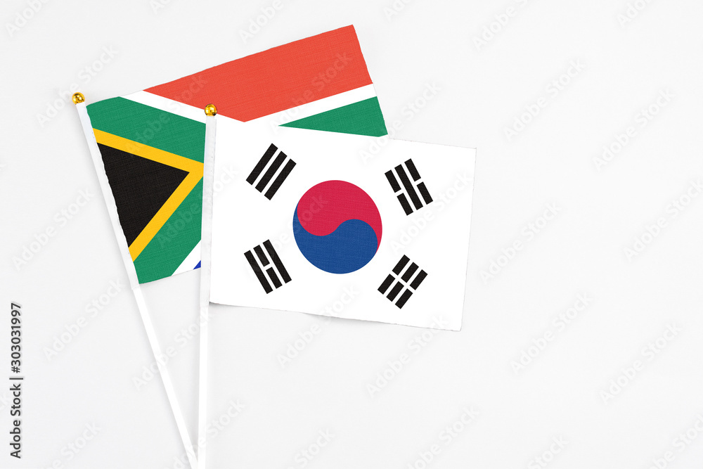 South Korea and South Africa stick flags on white background. High quality fabric, miniature national flag. Peaceful global concept.White floor for copy space.
