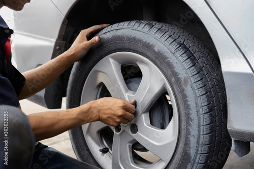 Man using car mechanic Block the wind wheel. To check your tires and brake for car.Auto mechanic Preparing For the work. © pic for you