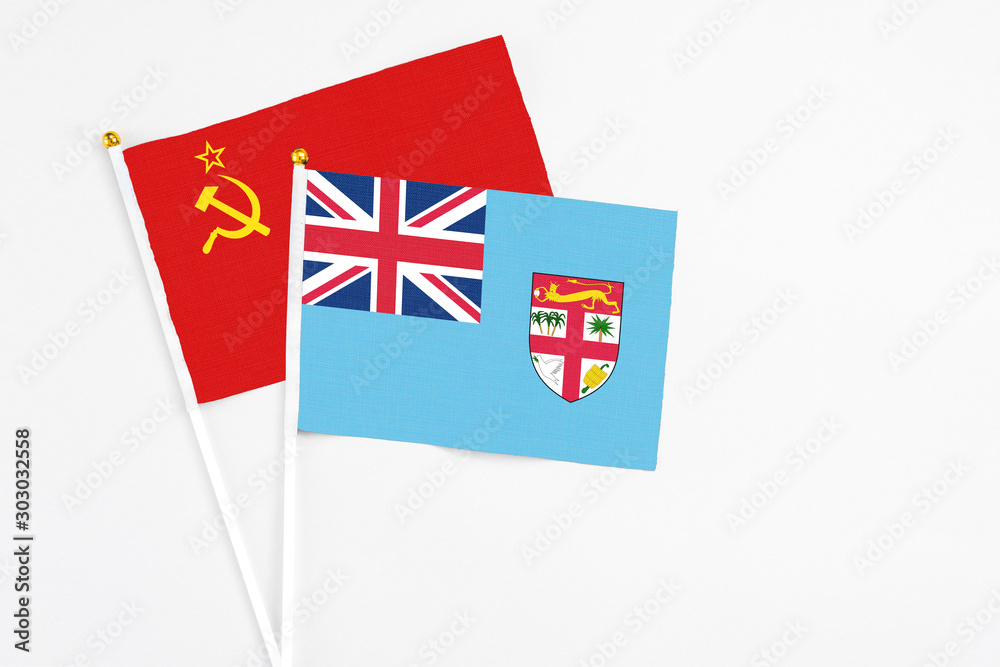 Fototapeta premium Fiji and Soviet Union stick flags on white background. High quality fabric, miniature national flag. Peaceful global concept.White floor for copy space.