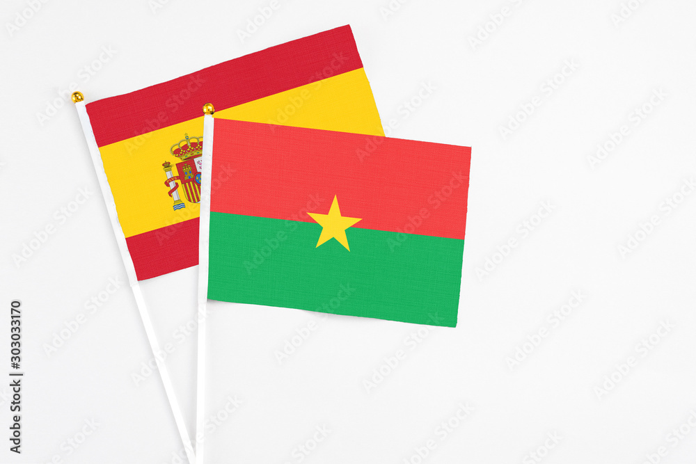 Burkina Faso and Spain stick flags on white background. High quality fabric, miniature national flag. Peaceful global concept.White floor for copy space. Burkina Faso and Spain stick flags on white background. High quality fabric, miniature national flag. Peaceful global concept.White floor for copy space.