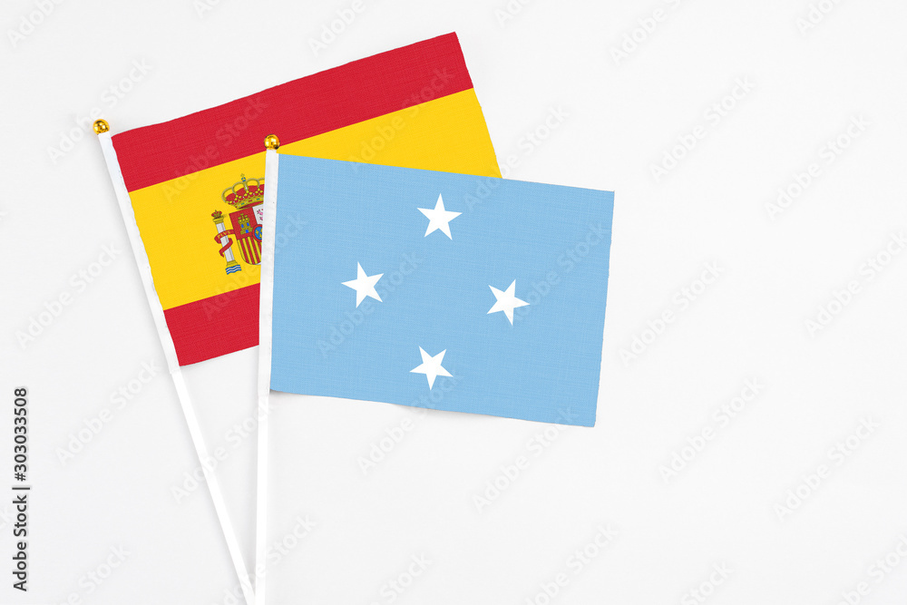 Micronesia and Spain stick flags on white background. High quality fabric, miniature national flag. Peaceful global concept.White floor for copy space. Micronesia and Spain stick flags on white background. High quality fabric, miniature national flag. Peaceful global concept.White floor for copy space.