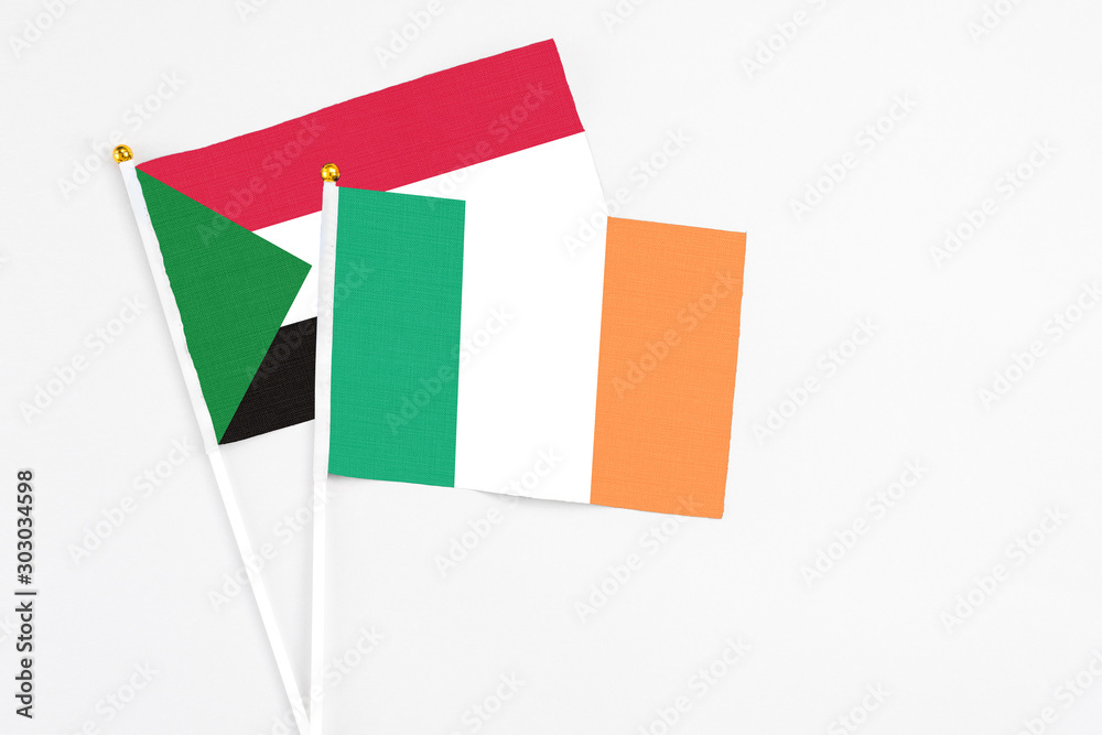 Ireland and Sudan stick flags on white background. High quality fabric, miniature national flag. Peaceful global concept.White floor for copy space. Ireland and Sudan stick flags on white background. High quality fabric, miniature national flag. Peaceful global concept.White floor for copy space.