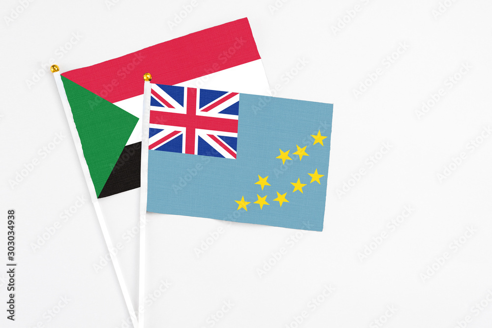 Tuvalu and Sudan stick flags on white background. High quality fabric, miniature national flag. Peaceful global concept.White floor for copy space. Tuvalu and Sudan stick flags on white background. High quality fabric, miniature national flag. Peaceful global concept.White floor for copy space.