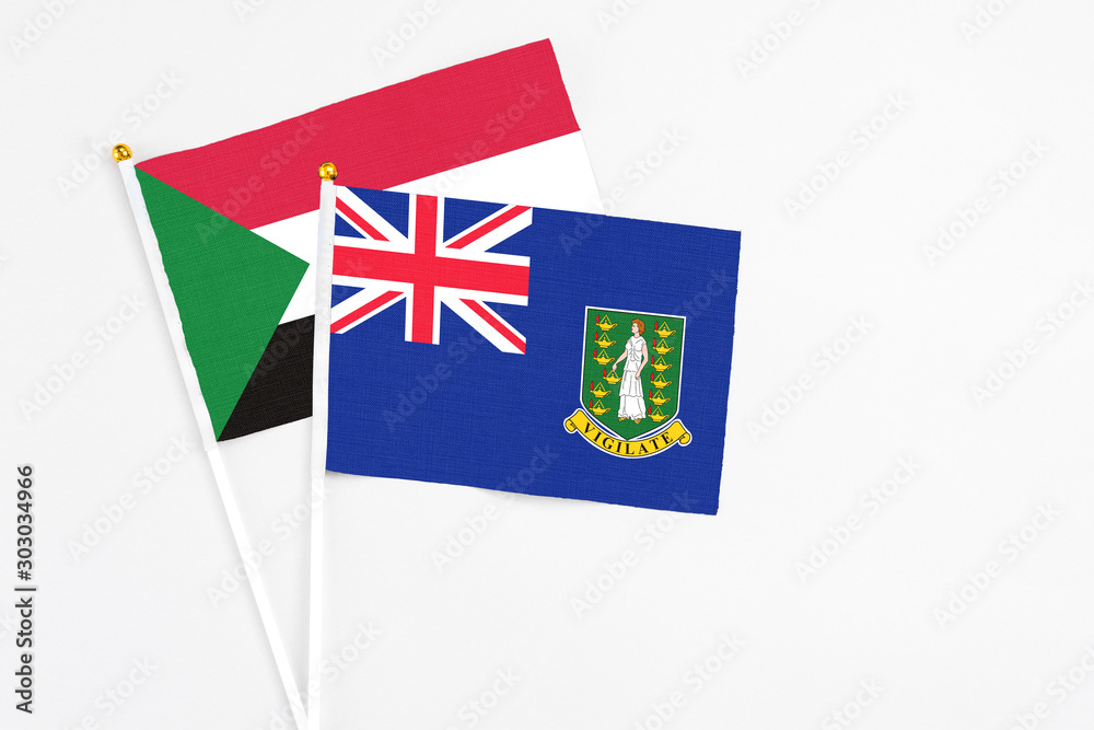 Fototapeta premium British Virgin Islands and Sudan stick flags on white background. High quality fabric, miniature national flag. Peaceful global concept.White floor for copy space.