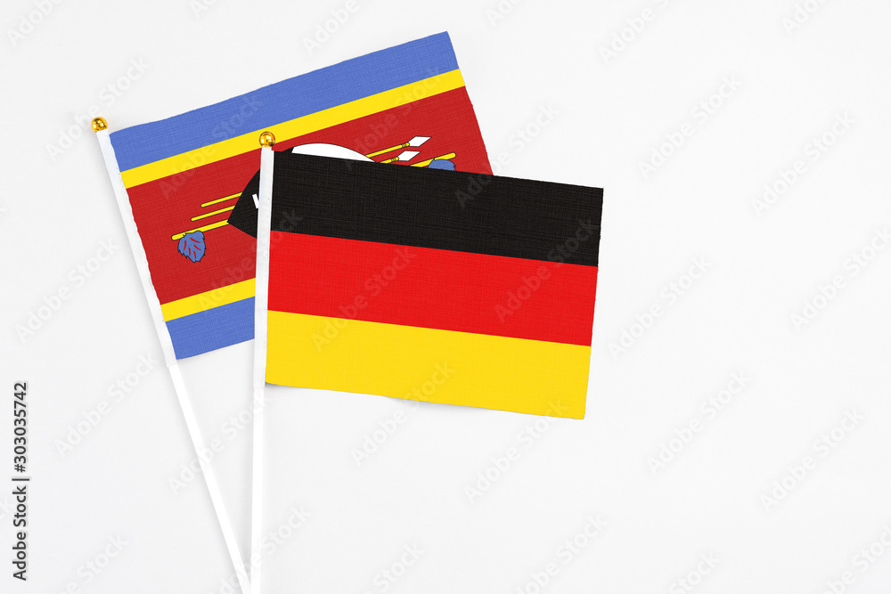 Germany and Swaziland stick flags on white background. High quality fabric, miniature national flag. Peaceful global concept.White floor for copy space. Germany and Swaziland stick flags on white background. High quality fabric, miniature national flag. Peaceful global concept.White floor for copy space.
