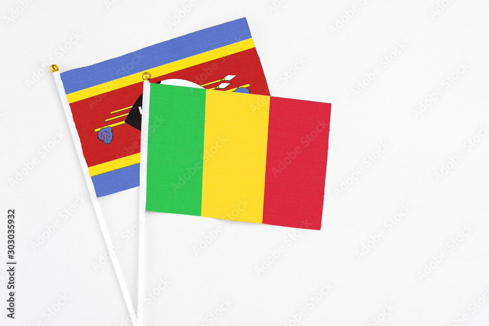 Mali and Swaziland stick flags on white background. High quality fabric, miniature national flag. Peaceful global concept.White floor for copy space. Mali and Swaziland stick flags on white background. High quality fabric, miniature national flag. Peaceful global concept.White floor for copy space.